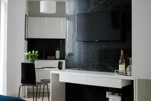 a kitchen with a counter with a tv on the wall at Apartament Marmurowy Kraków, Stare Miasto in Krakow