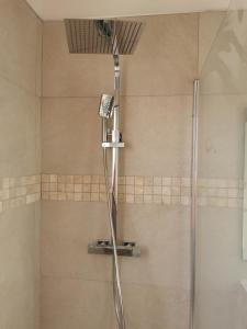 een douche met een douchekop in de badkamer bij Les logis de l'aqueduc in Ajaccio