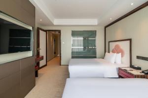 Postel nebo postele na pokoji v ubytování Suning Universal Hotel ALL-SUITES