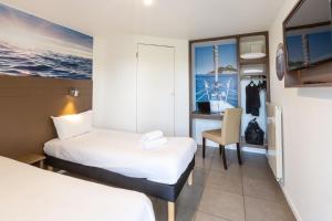 a hotel room with two beds and a desk at Hôtel Confort Le Moulin Rouge in Terrasson-Lavilledieu +22 photos