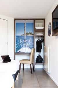 a bedroom with a window with a view of the ocean at Hôtel Confort Le Moulin Rouge in Terrasson-Lavilledieu