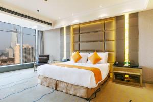 Postel nebo postele na pokoji v ubytování Suning Universal Hotel ALL-SUITES