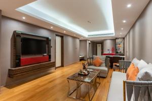 ein Wohnzimmer mit einem großen Flachbild-TV in der Unterkunft Suning Universal Hotel ALL-SUITES in Nanjing