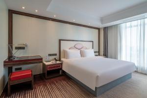 Postel nebo postele na pokoji v ubytování Suning Universal Hotel ALL-SUITES