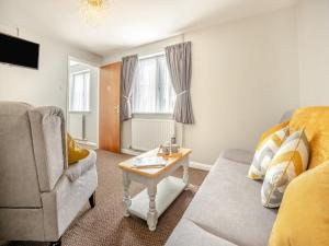 uma sala de estar com um sofá e uma mesa em Katelans Cottage - Uk42145 em North Somercotes