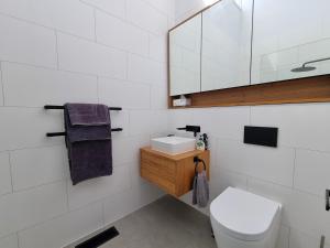 a bathroom with a toilet and a sink and a mirror at Sea Haven, A Rye Coastal Retreat! in Rye +7 photos