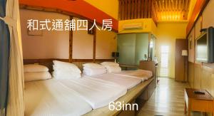 a large bed with white pillows in a room at 63inn庭園民宿 in Pinghe