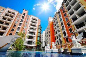a pool in a city with tall buildings at Espana Resort Pattaya Jomtien Beach in Jomtien Beach