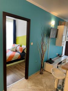 Un dormitorio con una cama, un escritorio y un espejo. en Aпартамент в Созопол, en Sozopol