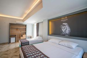 a bedroom with two beds and a large screen at Aslan Corner Hotel in Alanya