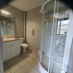 a bathroom with a shower and a toilet and a sink at HOTEL RESTAURANT Crêperie du Château in Craon