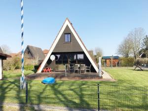 een huis met een gambrel dak en een tuin bij 50159 Ferienhaus Catharina in Carolinensiel