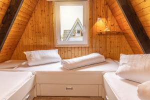 twee bedden in een houten kamer met een raam bij 50159 Ferienhaus Catharina in Carolinensiel