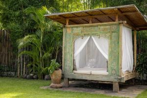 a gazebo with a white couch in a yard at Rimba Villas Gili Air in Gili Islands