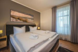 - une chambre avec un grand lit et 2 serviettes dans l'établissement Haus Strandoase 27, à Bansin
