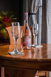 eine Flasche Wein und zwei Weingläser auf einem Tisch in der Unterkunft Breezy Beachfront Bali-Style Haven 180 Degree OceanView in Hauula + 26 Fotos