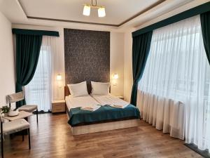 a bedroom with a bed and a large window at Vila President Sovata in Sovata