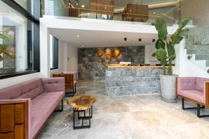a lobby with pink furniture and a bar at Lazar Lux Suites - Ammoudara in Agios Nikolaos