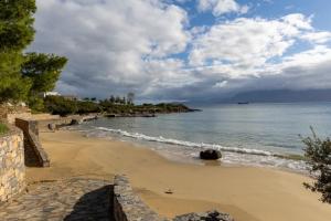 een uitzicht op een strand met de oceaan bij Lazar Lux Suites - Ammoudara in Agios Nikolaos