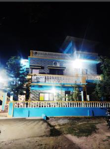 a blue building with lights in front of it at night at NISARG HOME STAY near Bus Stand Malvan in Malvan