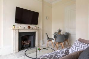 a living room with a fireplace with a tv above it at Cozy Flat in the Heart of London in London