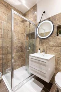 La salle de bains est pourvue d'une douche, d'un lavabo et d'un miroir. dans l'établissement Cozy Flat in the Heart of London, à Londres