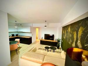 a living room with a couch and a kitchen at City Center Accommodation - 310 in Reşiţa