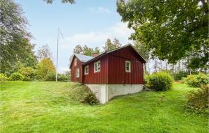 ein rotes Haus auf einem grasbewachsenen Feld mit Bäumen in der Unterkunft 3 Bedroom Cozy Home In Lngserud in Rullan