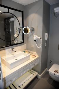 a bathroom with a sink and a mirror at Fame Residence Kemer & Spa in Kemer
