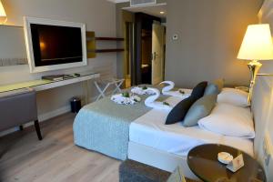 a hotel room with a bed with a tv on it at Fame Residence Kemer & Spa in Kemer
