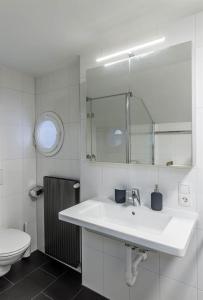 a white bathroom with a sink and a toilet at Haus Kapell in Schruns