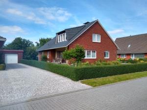 a red brick house with a driveway at FeWo Nordlicht in Hage