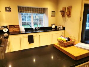 a kitchen with a sink and a counter with a basket at Historic, traditional & Spacious Wiltshire Cottage in Shrewton