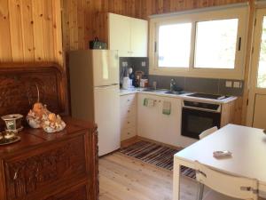 cocina con nevera blanca y mesa en Pervolaris Cottages 1, en Goudhi