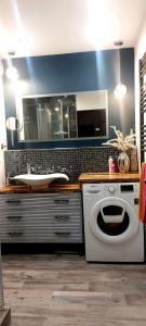 a bathroom with a sink and a washing machine at Private Apartment Laatzen City in Hannover