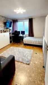 a living room with a couch and a desk at Private Apartment Laatzen City in Hannover