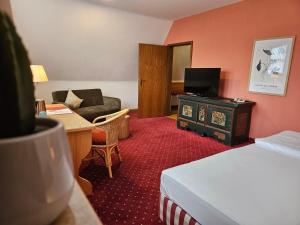 a hotel room with a bed and a living room at Landhotel Ölmühle in Mömbris