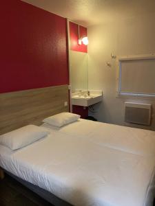 sypialnia z dużym białym łóżkiem i umywalką w obiekcie HOTEL F1 SAINT-LO w mieście Saint-Lô