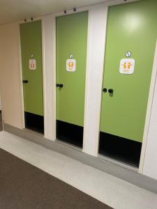 rząd zielonych drzwi z znakami na nich w obiekcie HOTEL F1 SAINT-LO w mieście Saint-Lô