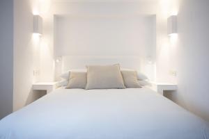 a white bed with white pillows in a bedroom at Pagoda Lifestyle Hotel in Ischia