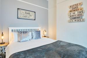 um quarto com uma cama branca e almofadas azuis em Apartment 1 - Khyber Lodge Apartments em Whitby