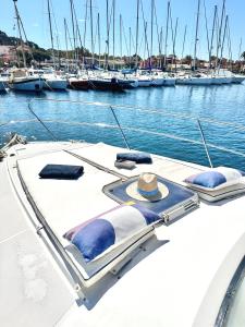 un bateau dans un port de plaisance avec des bateaux dans l'eau dans l'établissement HEBERGEMENTS BATEAUX A QUAI, à Porquerolles