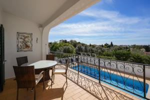 a balcony with a table and chairs and a view of a pool at Casa Manjua in Carvoeiro