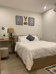 1 dormitorio con 1 cama y escritorio con lámpara en A cozy condotel in Bai Sau(1 bed and 1 sofa bed) en Vung Tau