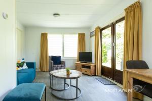 sala de estar con sofá azul y TV en Bed & Breakfast Meinsma, en Moddergat