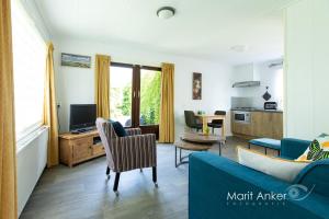 a living room with a couch and a tv at Bed & Breakfast Meinsma in Moddergat