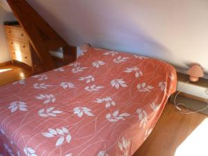 Una cama con colcha roja con flores blancas. en Les hortensias, 