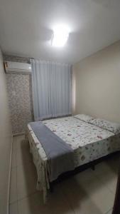 um quarto com uma cama num quarto em APTO ACONCHEGANTE 1KM DA Praia do aracagy e 4KM DA Litorânea em São Luís