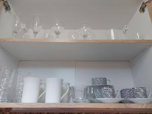 a shelf with glasses and cups on it at Angie's House Volos in Volos +9 photos