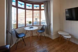 um quarto com uma mesa e cadeiras e uma janela em Apartment 2, Khyber Lodge Apartment Whitby em Whitby